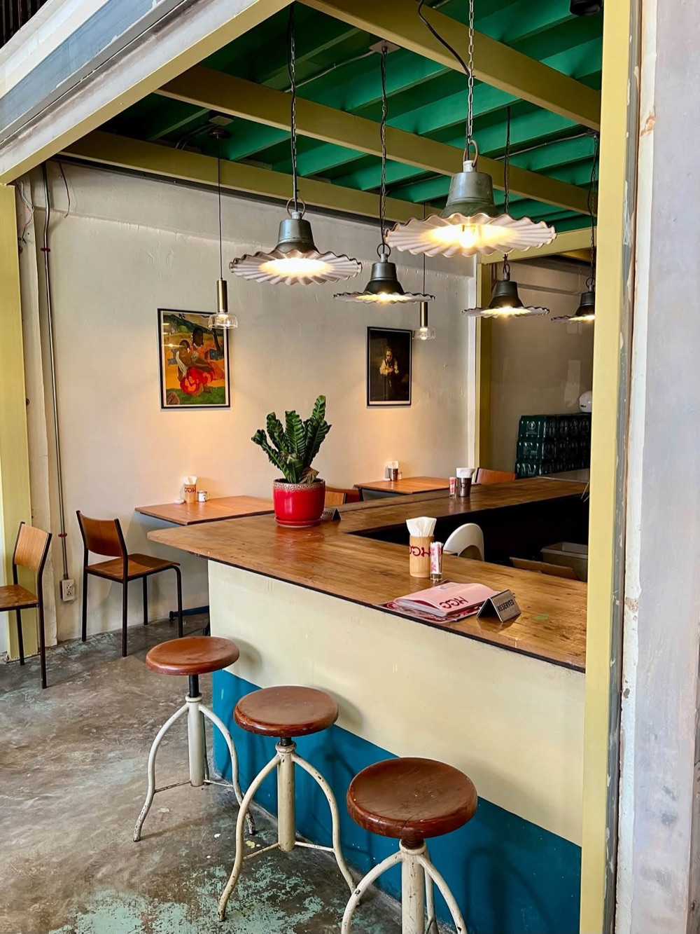 Wooden counter, stools and pendant lamps inside homm.bkk